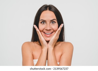 Extremely Happy Caucasian Young Woman In Spa Bath Towel Touching Her Face Looking At Camera Isolated In White Background. Skin And Beauty Care Treatment