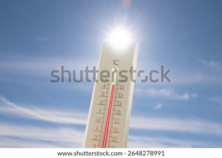 Extremely high temperature on thermometer against blue sky on sunny day. Summer weather
