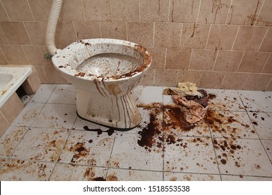 Extremely messy toilet in a dirty bathroom, very bad condition