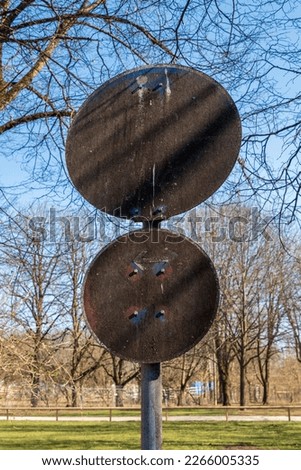Extremely polluted German, foot and cycle path traffic sign and an absolute no stopping sign at a park in sunshine