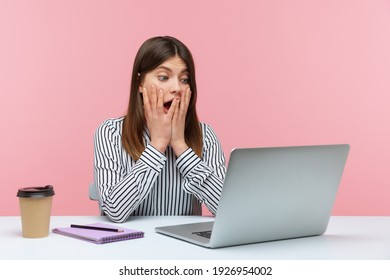 Extremely Shocked Surprised Woman Office Worker Looking At Laptop Display With Big Eyes And Open Mouth, Confused With Information. Indoor Studio Shot Isolated On Pink Background