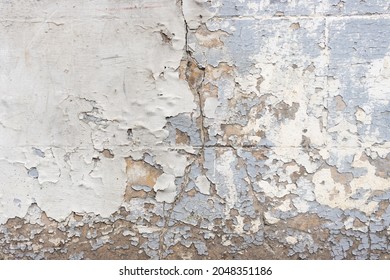 Extremely weathered facade wall.  few layers of paint peeling of the wall, showing cracked brown coating stucco. Cracks, missing patches of paint and blisters on the surface of paint. - Powered by Shutterstock