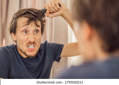 Extremly Tired Young Man Looking At Himself In The Mirror, Home Alone. Self-isolation At Home, Quarantine Due To Pandemic COVID 19. Mental Health Problems In Self-isolation At Home