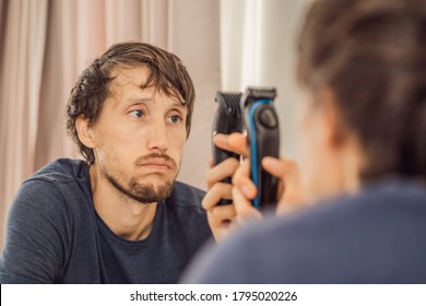 Extremly Tired Young Man Looking At Himself In The Mirror, Home Alone. Self-isolation At Home, Quarantine Due To Pandemic COVID 19. Mental Health Problems In Self-isolation At Home