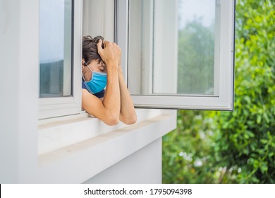 Extremly Tired Young Man Looking Out The Window, Home Alone. Self-isolation At Home, Quarantine Due To Pandemic COVID 19. Mental Health Problems In Self-isolation At Home