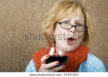Extroverted woman with a funny expression drinking red wine