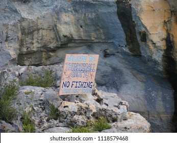 EXUMA CAYS, BAHAMAS—JANUARY 2018: Sign Board At The Rocky Cliffs Of The Thunderball Grotto. The Location Is A Popular Destination And Has Been Used For Filming Several Movies.