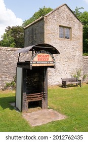 Eyam, Derbyshire, UK
July 20  2021
The Hog Roast Grill Stands In A Corner Of This Derbyshire Plague Village With Stone Built Walls And Ancient Building Behind.