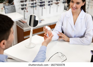 Eye Care Concept. Smiling Female Optician Specialist Giving Plastic Case With Contact Lenses To Patient Sitting At Desk. Ophthalmology, Optometry, Vision And Eyesight. Consultation At Doctor's Office