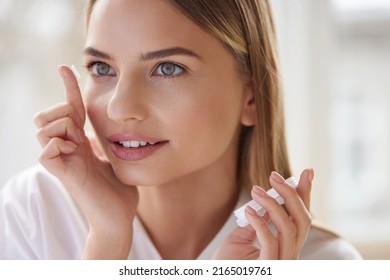 Eye care. Smiling Woman With Contact Eye Lens on Finger Closeup. Portrait of Beautiful Blonde Girl Putting Contacts Lenses in Eyes. Vision Health Concept 