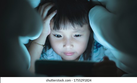 Eye Close Up Little Girl Are Watching Video In Tablet On Bed At Night Time Light Flashes Reflected From The Screen,children Using Games With Addiction And Cartoon Concepts