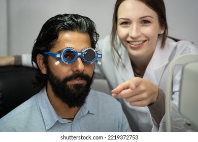 An Eye Doctor Examines A Male Patient In A Clinic With Modern Equipment.