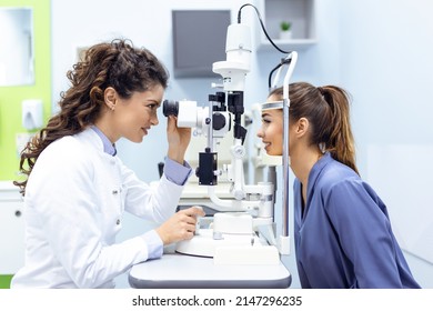 Eye doctor with female patient during an examination in modern clinic. Ophthalmologist is using special medical equipment for eye health saving and improving. - Powered by Shutterstock