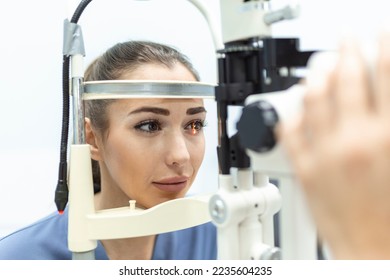 Eye doctor with female patient during an examination in modern clinic. Ophthalmologist is using special medical equipment for eye health - Shutterstock ID 2235604235