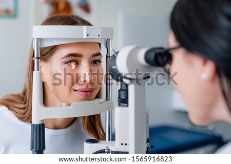 Eye doctor with female patient during an examination in modern clinic