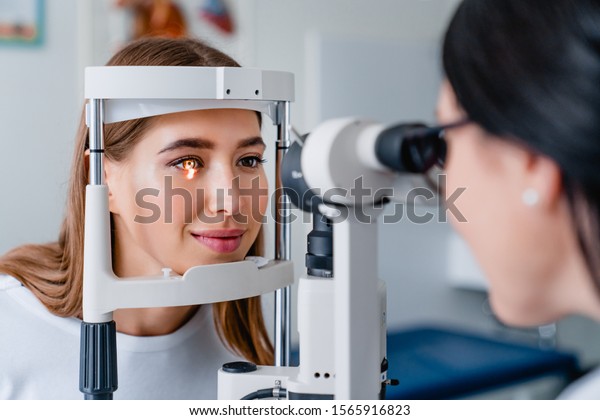 Eye doctor with female patient during an\
examination in modern\
clinic