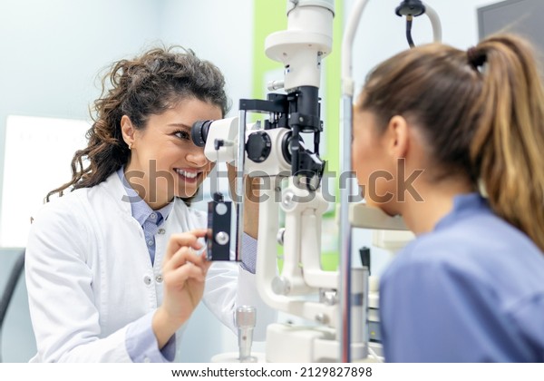 Eye doctor with female patient\
during an examination in modern clinic. Ophthalmologist is using\
special medical equipment for eye health saving and\
improving.