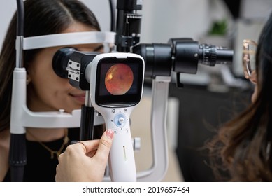 	
Eye doctor performing an eye fundus examination with retinal camera.