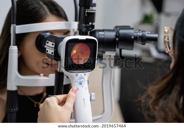 	\
Eye doctor performing an eye fundus\
examination with retinal\
camera.