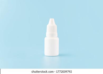 Eye Drop Or Ear Drop Bottle On Light Blue Background. Blank White Plastic Container For Fluid. Pharmaceutical Packaging Product.