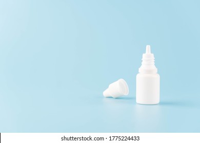 Eye Drop Or Ear Drop Bottle On Light Blue Background. Blank White Plastic Container For Fluid. Pharmaceutical Packaging Product.