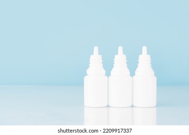 Eye Drop Or Ear Drop Bottles On Light Blue Background. Blank White Plastic Container For Fluid. Pharmaceutical Packaging Product. 