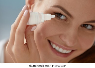 Eye Drop. Woman Applying Lubricant Eye Drops In Her Eyes Closeup. Happy Smiling Girl With Artificial Tears Bottle