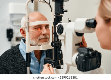 Eye exam of mature men consulting doctor for eyesight at optometrist or ophthalmologist. Face of senior customer testing vision with optician helping or testing iris or retina visual health. - Powered by Shutterstock