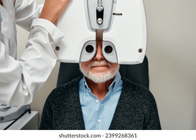 Eye examination of a mature man with diagnostic ophthalmology in an optical clinic. Professional ophthalmological examination of the patient's vision. Phoropter machine, eye health check. - Powered by Shutterstock