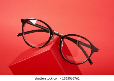 eye glasses on red gift box red background copy space