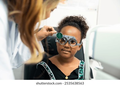 Eye impaired young girl patient getting eyesight checkup examined and treated by specialist eye doctor, using trial frame to treat vision. Healthcare eye clinic eyeglass store. - Powered by Shutterstock