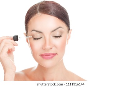 Eye Lash Gel Serum. Woman Applying Serum Essence Essential Oils To Her Eyelashes For Growth Strong Effect Solution With Eyes Closed Isolated On White. Positive Face Expression Mixed Race Latina Girl