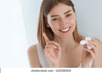 Eye lens. Smiling woman with contact eye lenses and container in hand. Girl applying eye contacts from lens box. Eye health care concept