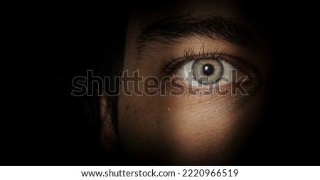 eye looking through crack  in the shadows
