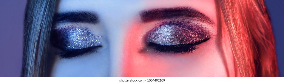Eye Makeup. Beautiful Eyes Glitter Make-up. Holiday Makeup detail. False Lashes. woman in colorful bright lights  with trendy make-up.