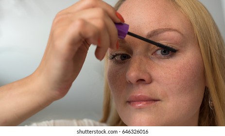 Eye makeup.Young woman applying mascara make-up