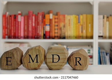 Eye Movement Desensitization and Reprocessing psychotherapy treatment concept. Letters EMDR written on wooden irregular blocks. - Shutterstock ID 2117047460
