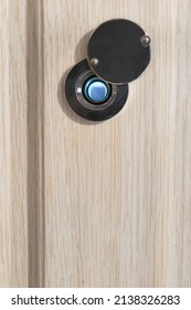 Eye Peephole In White Wooden Door Closeup