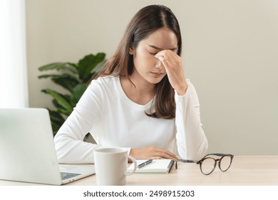 Eye problem concept, fatigue asian young woman tired eyes, irritated rubbing eye dry relief vision pain after work on laptop computer, eye strain, hand holding glasses, suffer migraine, bad blurry - Powered by Shutterstock