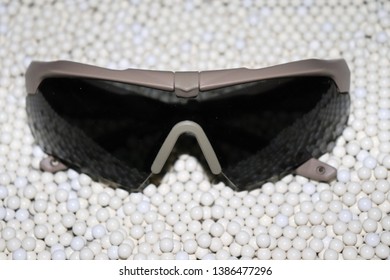 eye protection goggles (military glasses) for airsoft games on the background of perfect round white balls