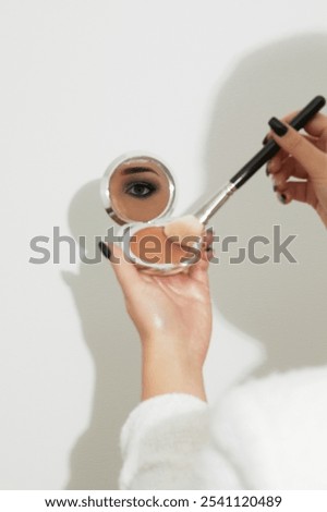 Eye reflection in mirror during makeup application – artistic composition