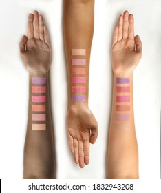 Eye shadow swatches on female hands with different skin color isolated oin a white background. Decorative cosmetics. Top view