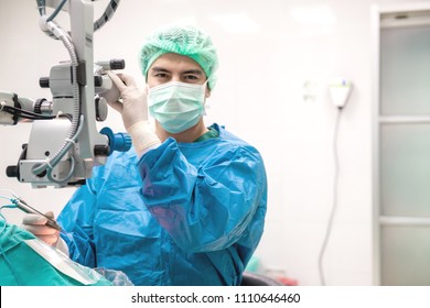 Eye surgeon at work. Young caucacian male surgeon performing surgery on a senior patient. Real operating theater room. Medical concept.