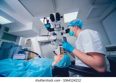 Eye surgery. A patient and surgeon in the operating room during ophthalmic surgery. Patient under surgical microscope. Vision correction
