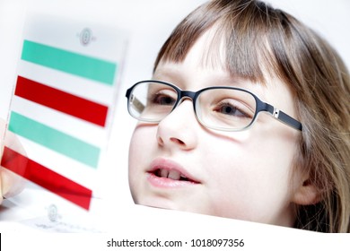 Eye Vision Therapy. Child With Red Green Reading Bar And Glasses