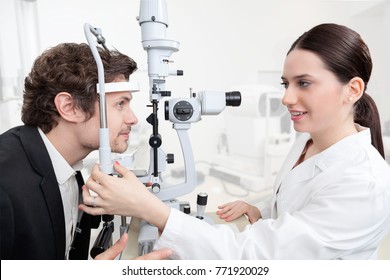 Eye Woman Doctor Adjusting Slit Lamp / Handsome Man During A Cornea Exam / The Oculist In Eyes Clinic Doing Crystalline Lens Diagnostic / High Technology Concept Eyes Care