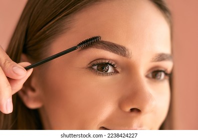 Eyebrow care up close. Cute young woman doing eyebrow styling.
