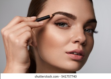 Eyebrows Shaping. Portrait Of Sexy Young Girl With Brow Pencil. Closeup Of Beautiful Glamourous Woman With Professional Makeup Contouring Brows With Eyebrow Pencil. Beauty Concept. High Resolution