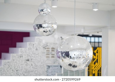 Eye-catching disco balls dangle from the ceiling, adding a fun and festive feel to the modern space, perfect for events, parties, or celebrations.