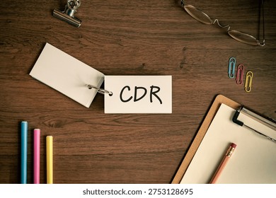 Eye-catching image of CDR text on word card. The word stands for Carbon Dioxide Removal. Shown with pens, clipboard, glasses.